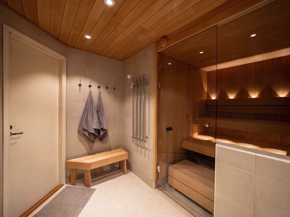 Kylpyhuone ja lasiseinällä erotettu sauna
